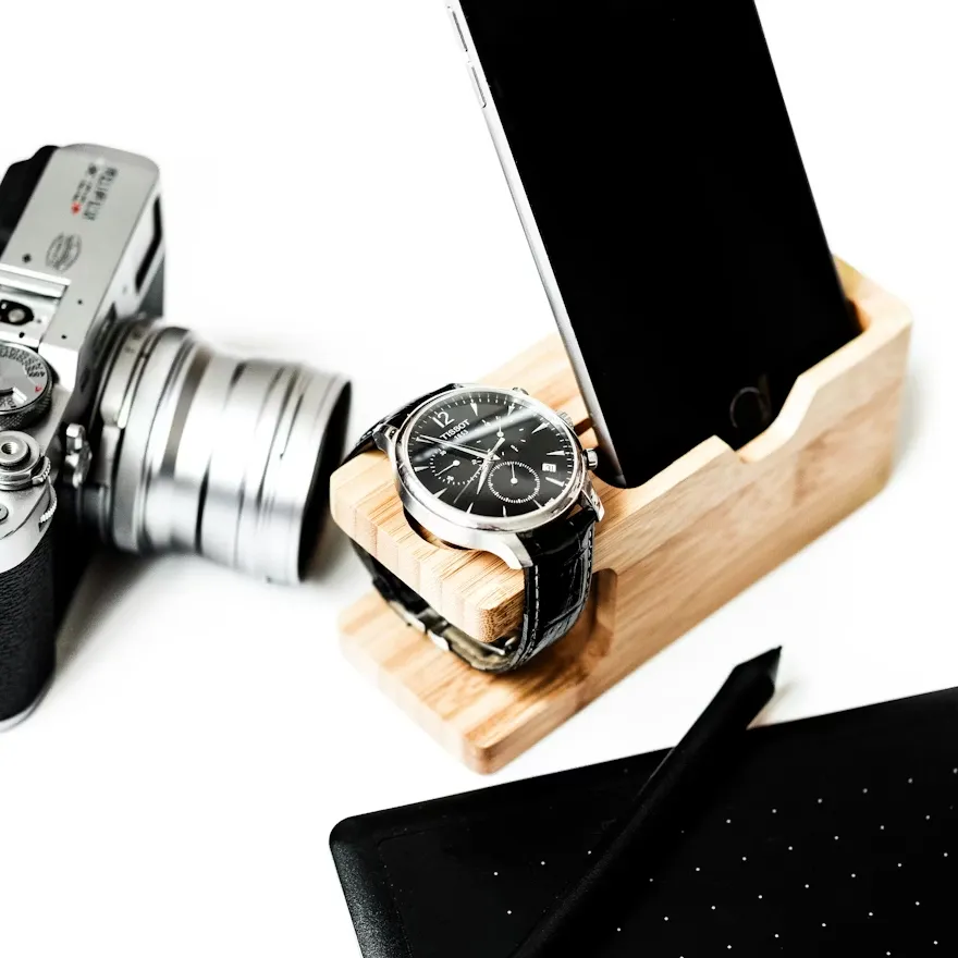 木製スマホスタンドと腕時計とカメラ